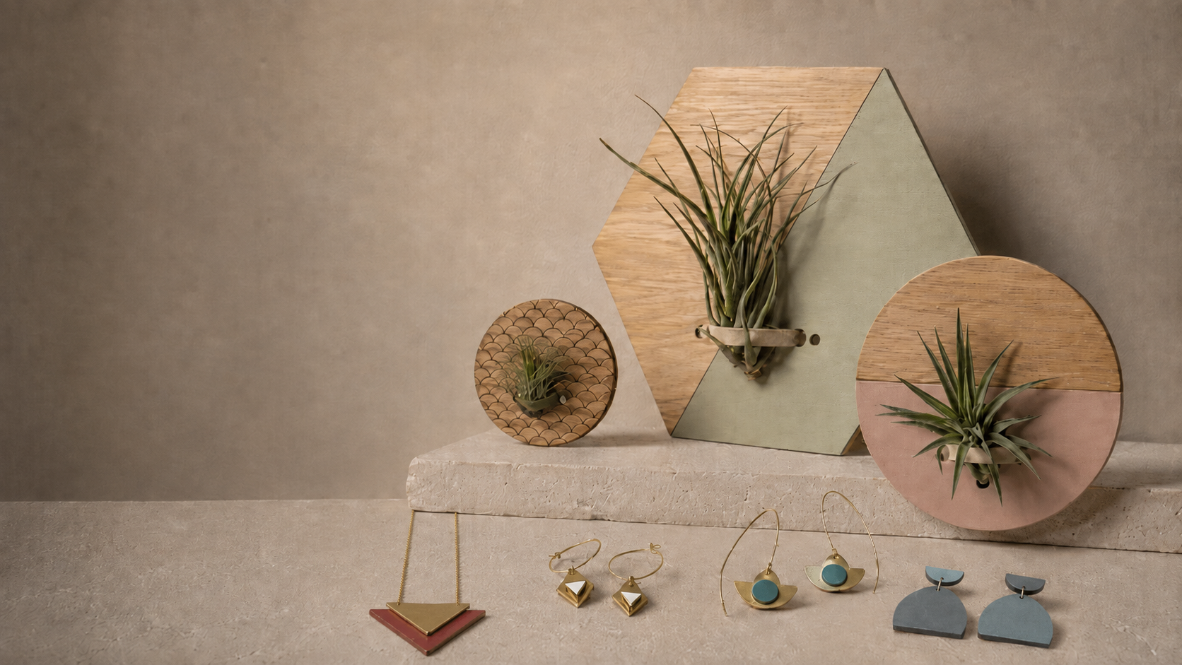 Geometric painted plywood earrings and wall objects arranged on warm cream